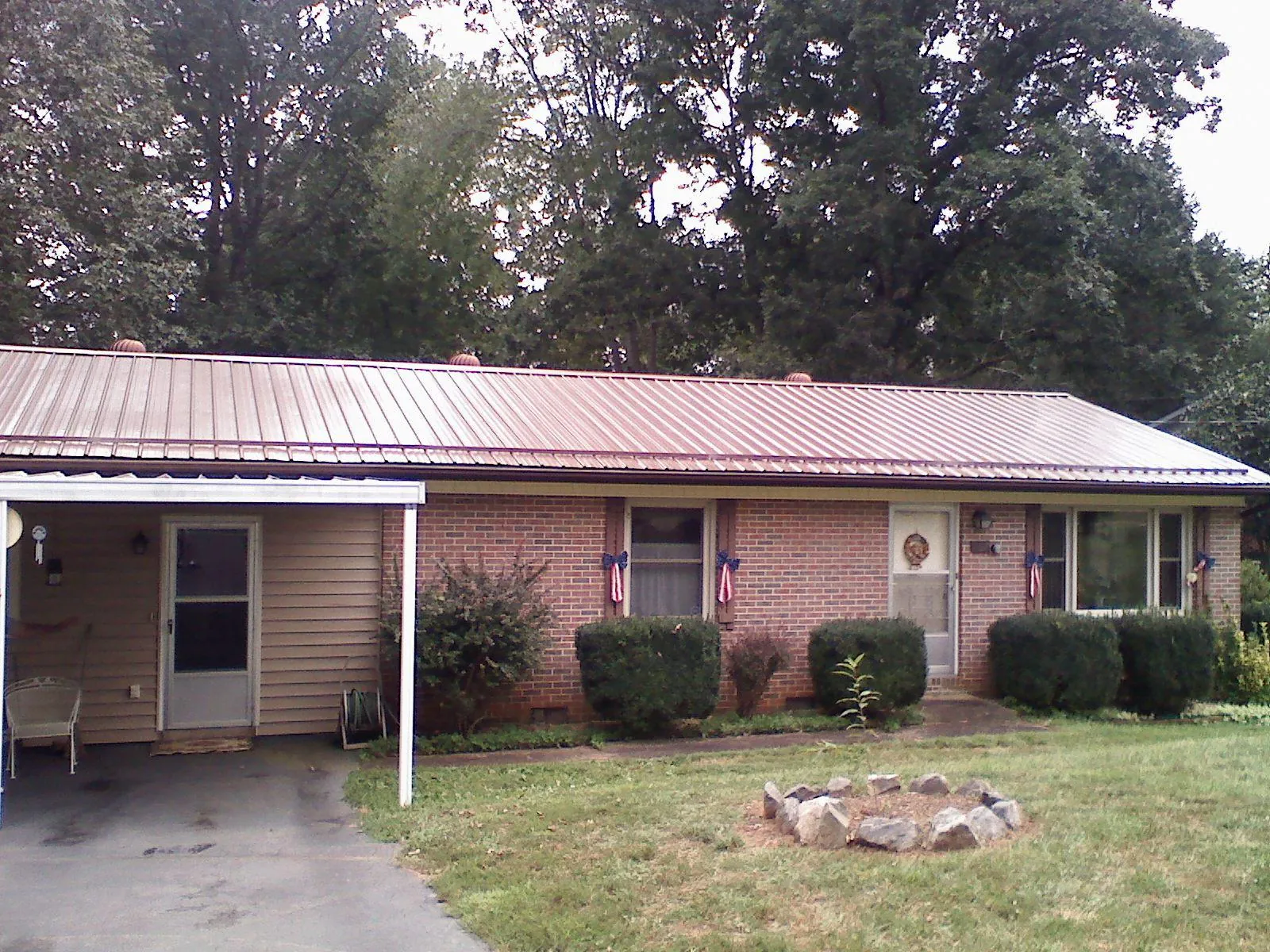 Bronze metal roof and carport on a brick ranch home — Roof Repair work by our crew in Linden